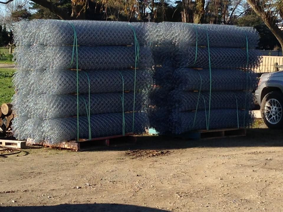 A large stack of chain link fence is sitting on a pallet