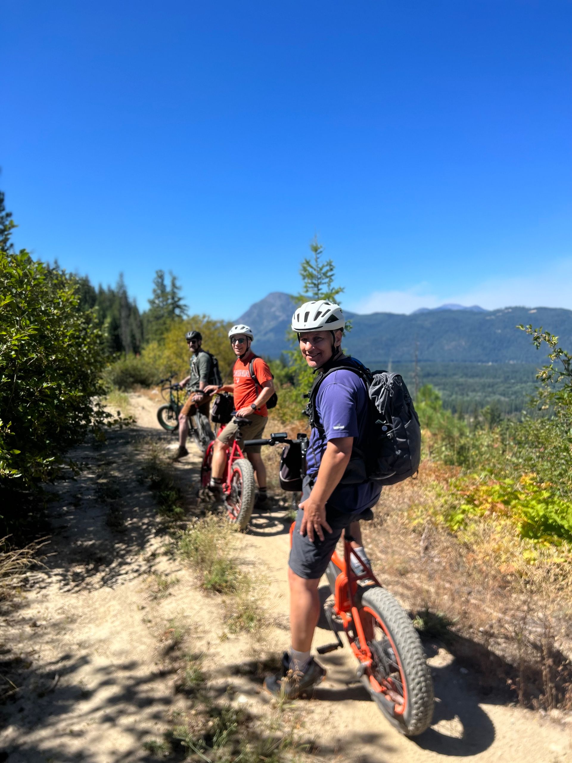 A man is riding a bike on a dirt road.