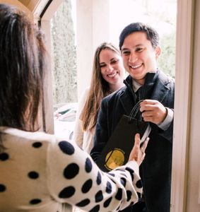 guests bringing a bottle of champagne to a house party.