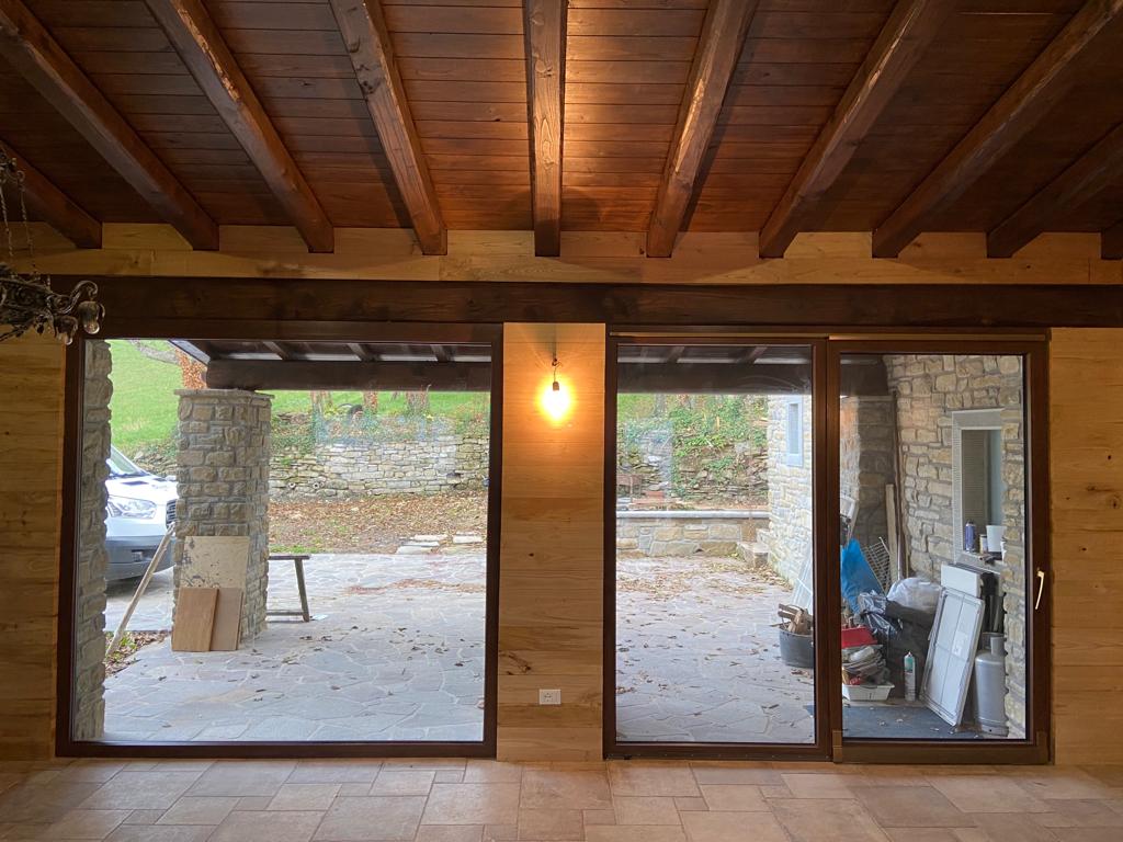 Una stanza con molte finestre e un soffitto in legno