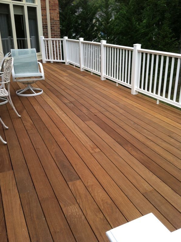 Wooden deck with white railing and outdoor furniture.