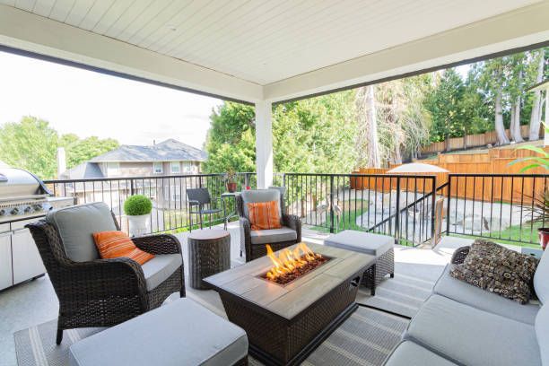 Covered patio with seating area, fire pit, and view of backyard.