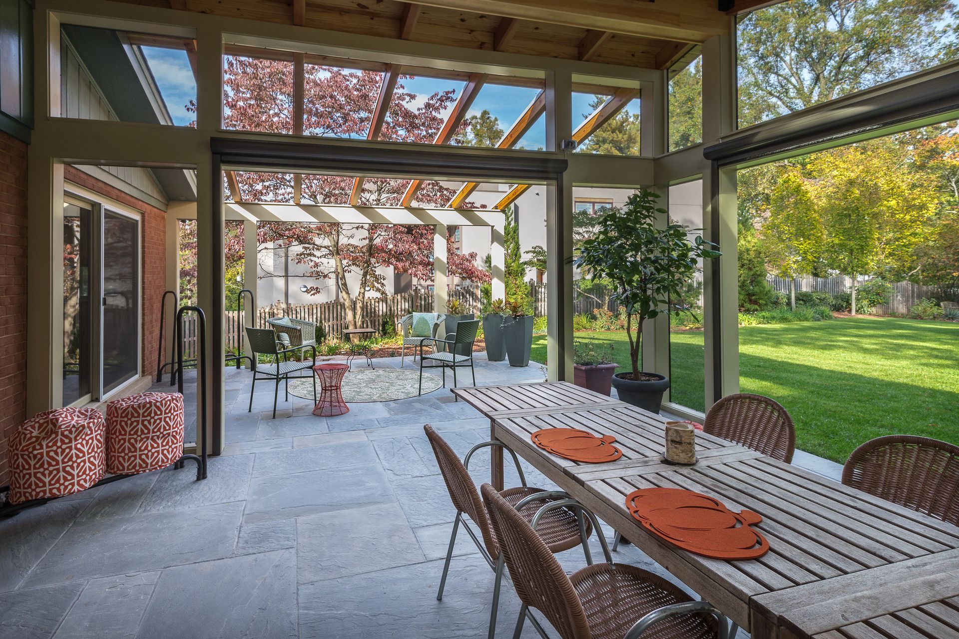 Outdoor patio with dining table, chairs, and garden view.