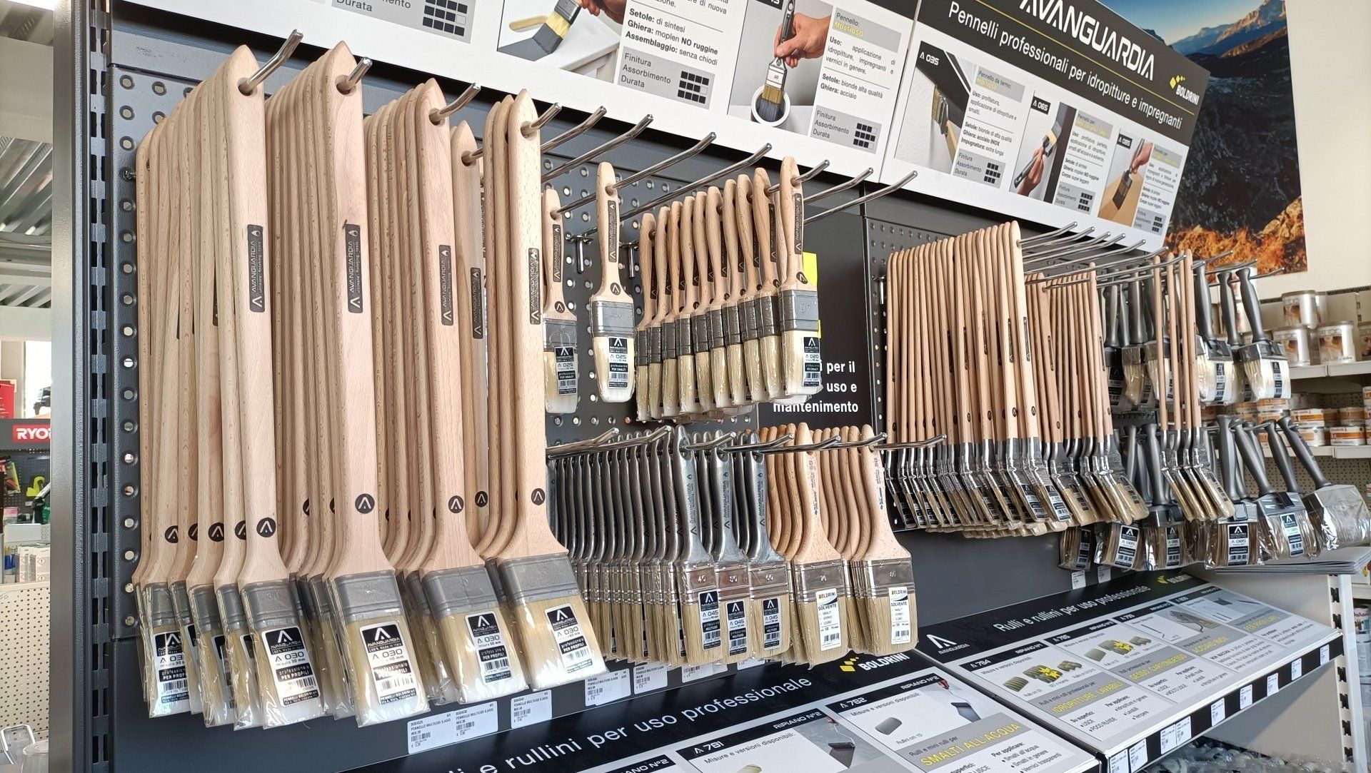 Scaffale del negozio che espone un assortimento di utensili da cucina con manico in legno, confezionati singolarmente.