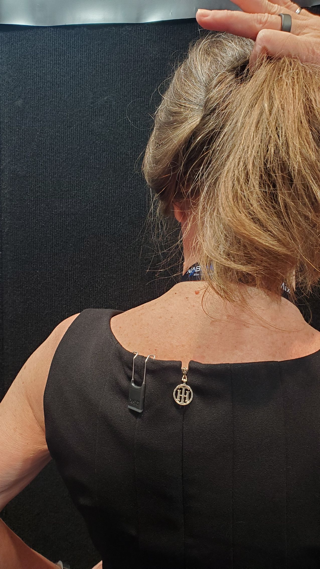PlayerMic FlexClip shown worn on the upper back under a woman's black dress
