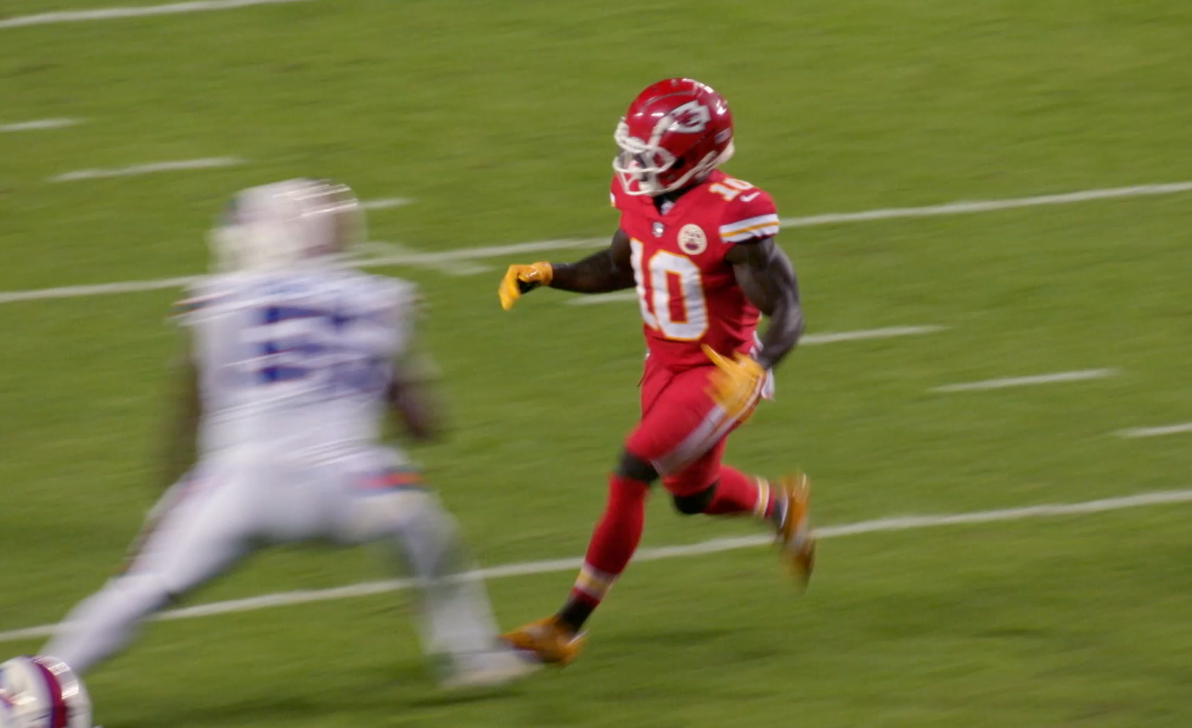 NFL Kansas City Chiefs player running towards a blurred defenseman