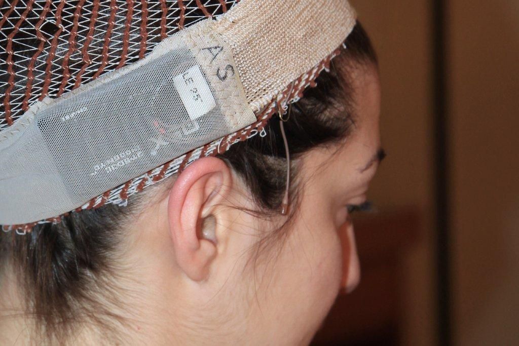 Q5X wireless microphone transmitter embedded in a fabric band around a woman's head to be hidden under a wig in theatre 