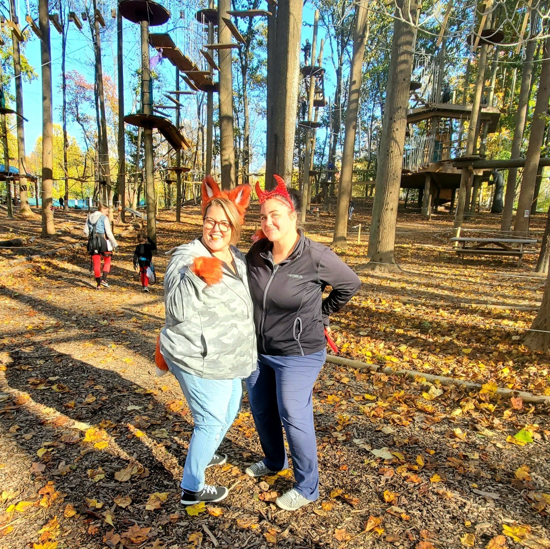 2 Moms dressed up for Halloween watching children climb