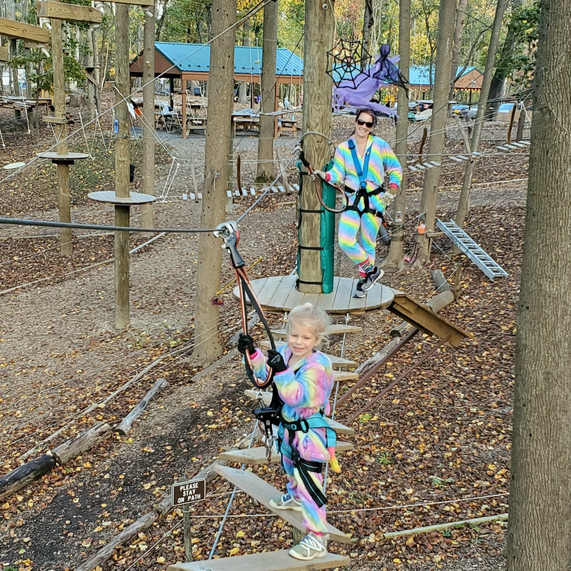 Mom and daughter climbing on high ropes course dressed as unicorns