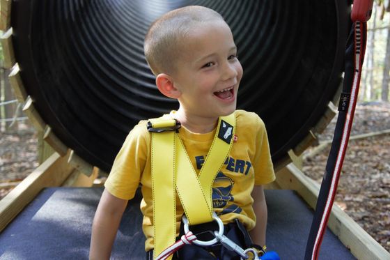 Young boy smiling after going down a slide