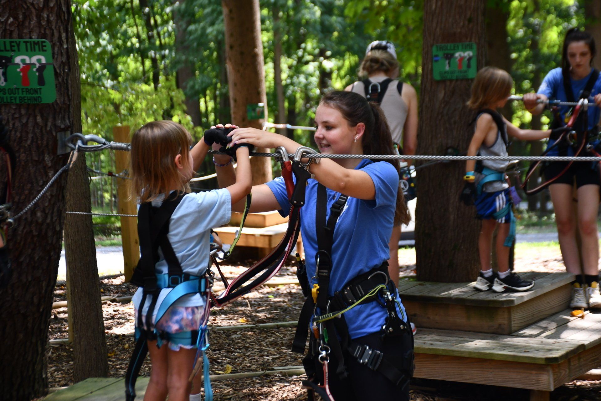 Staff helping young girl on ropes course