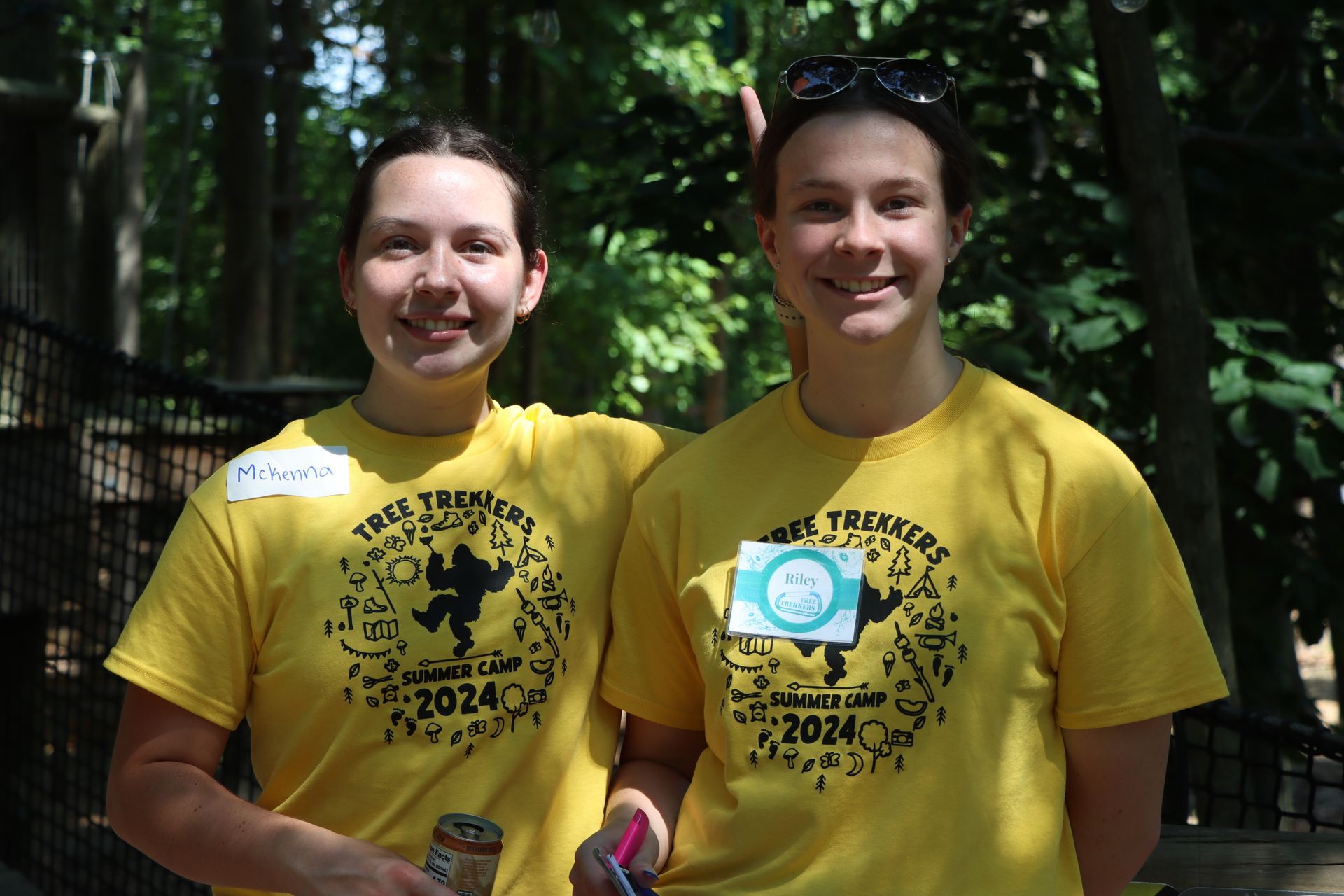Two camp counselors wearing yellow shirts with the year 2024 on them