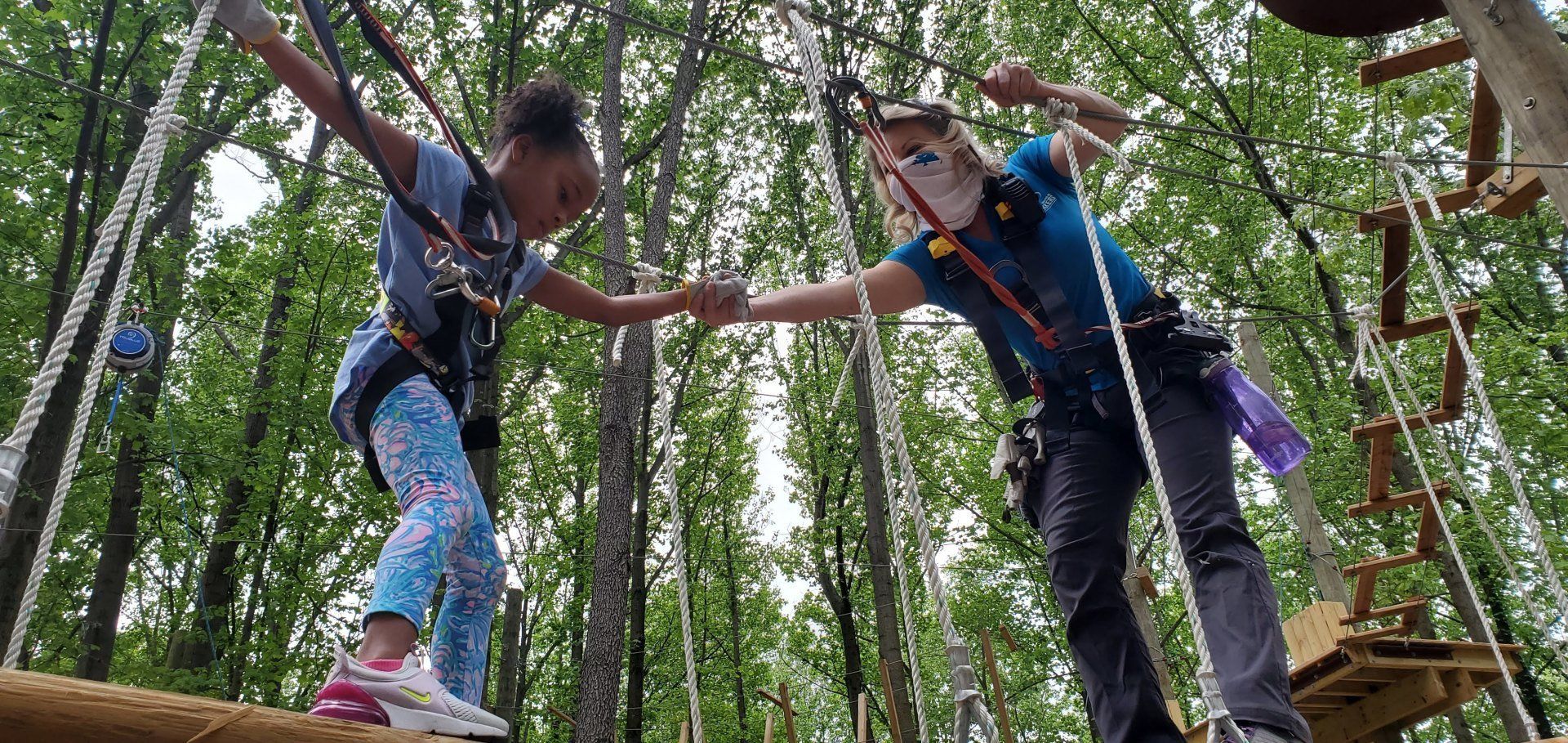 Adult female and and young girl climbing together