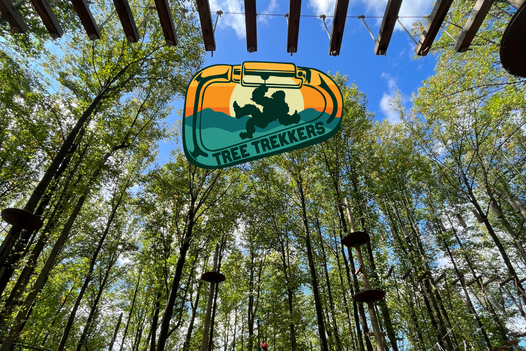 Tree Trekkers logo over a forest canopy with tall trees and blue sky.