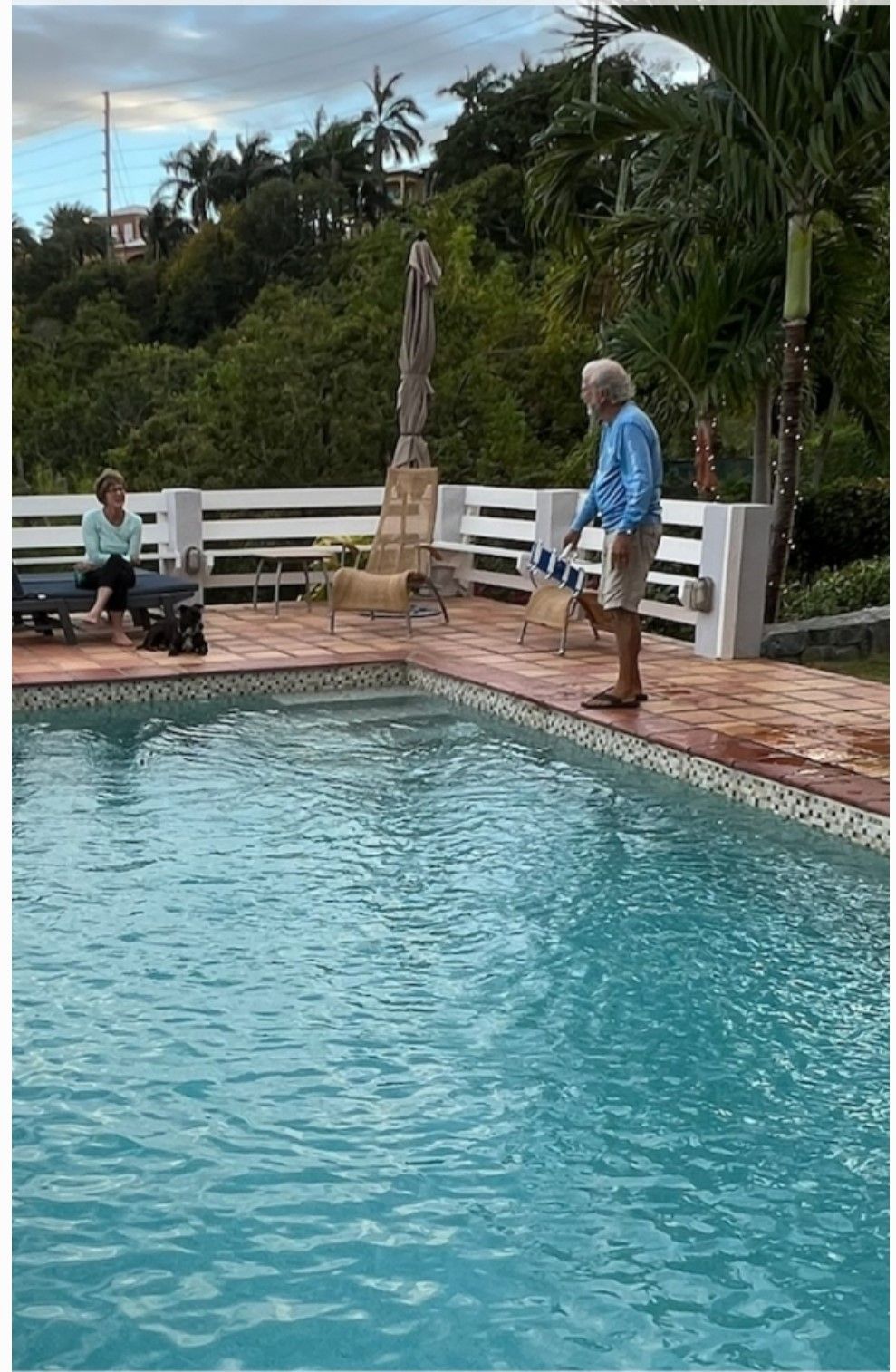 A pool with 2 people in the poolside.
