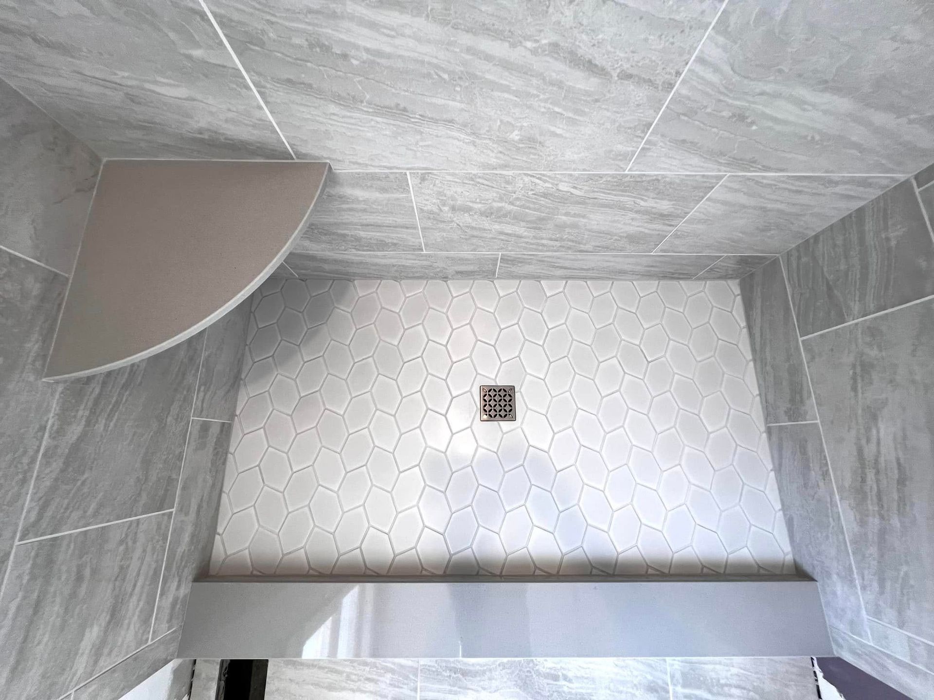A bathroom with a walk in shower and a corner shelf.
