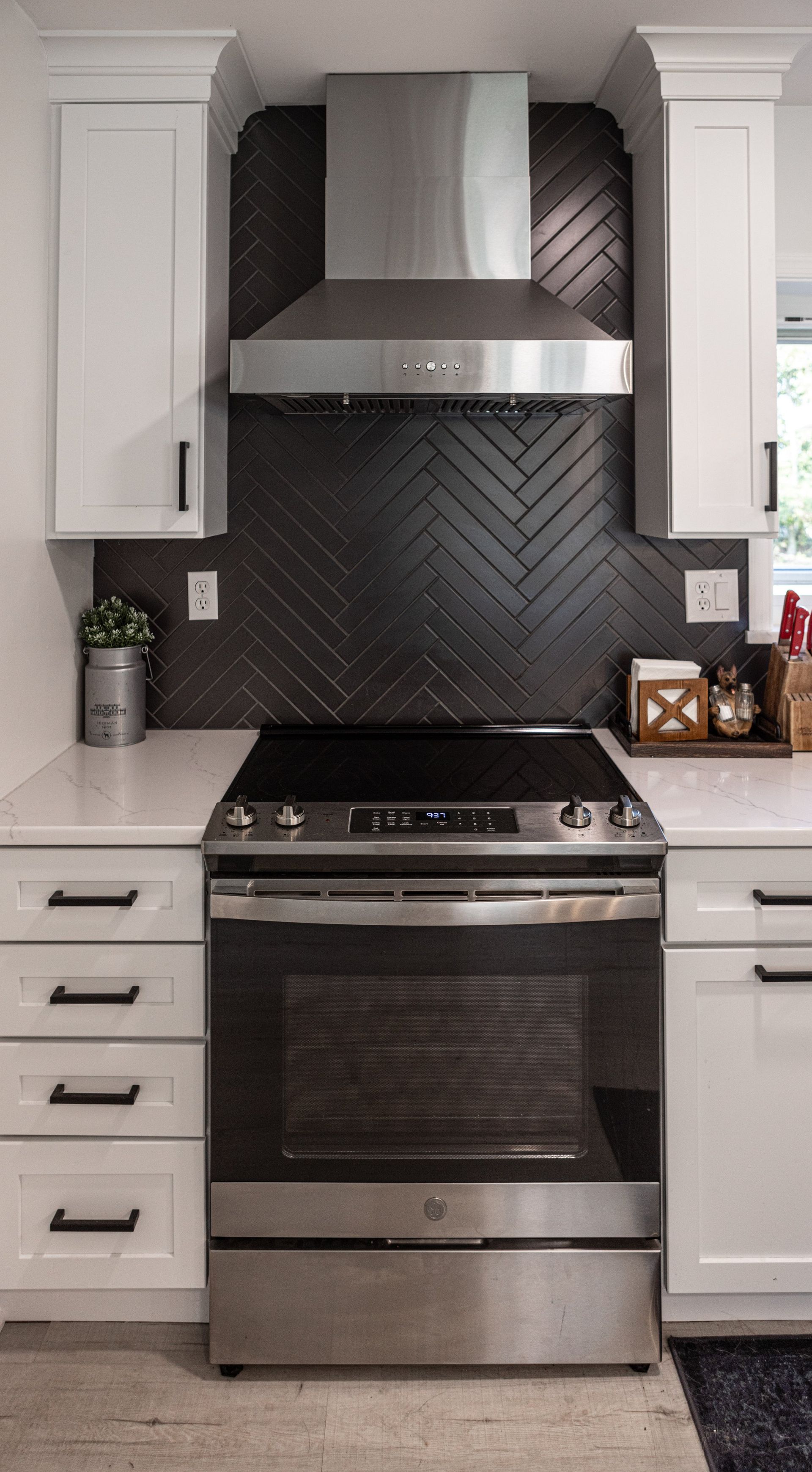 A kitchen with stainless steel appliances and white cabinets.