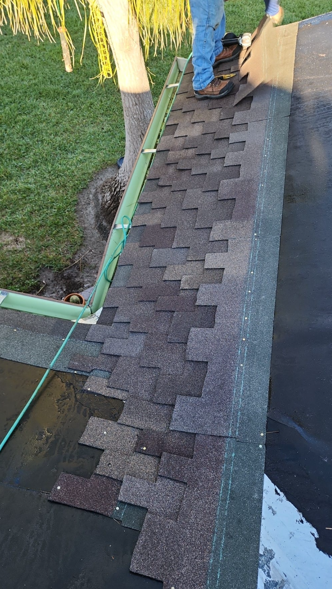 A person is working on a roof with a shovel.