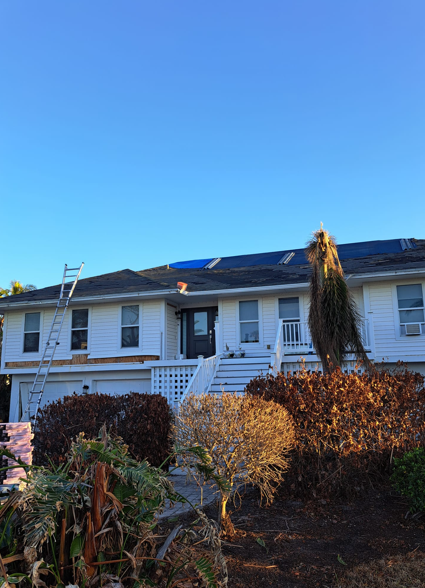A man is working on the roof of a house.