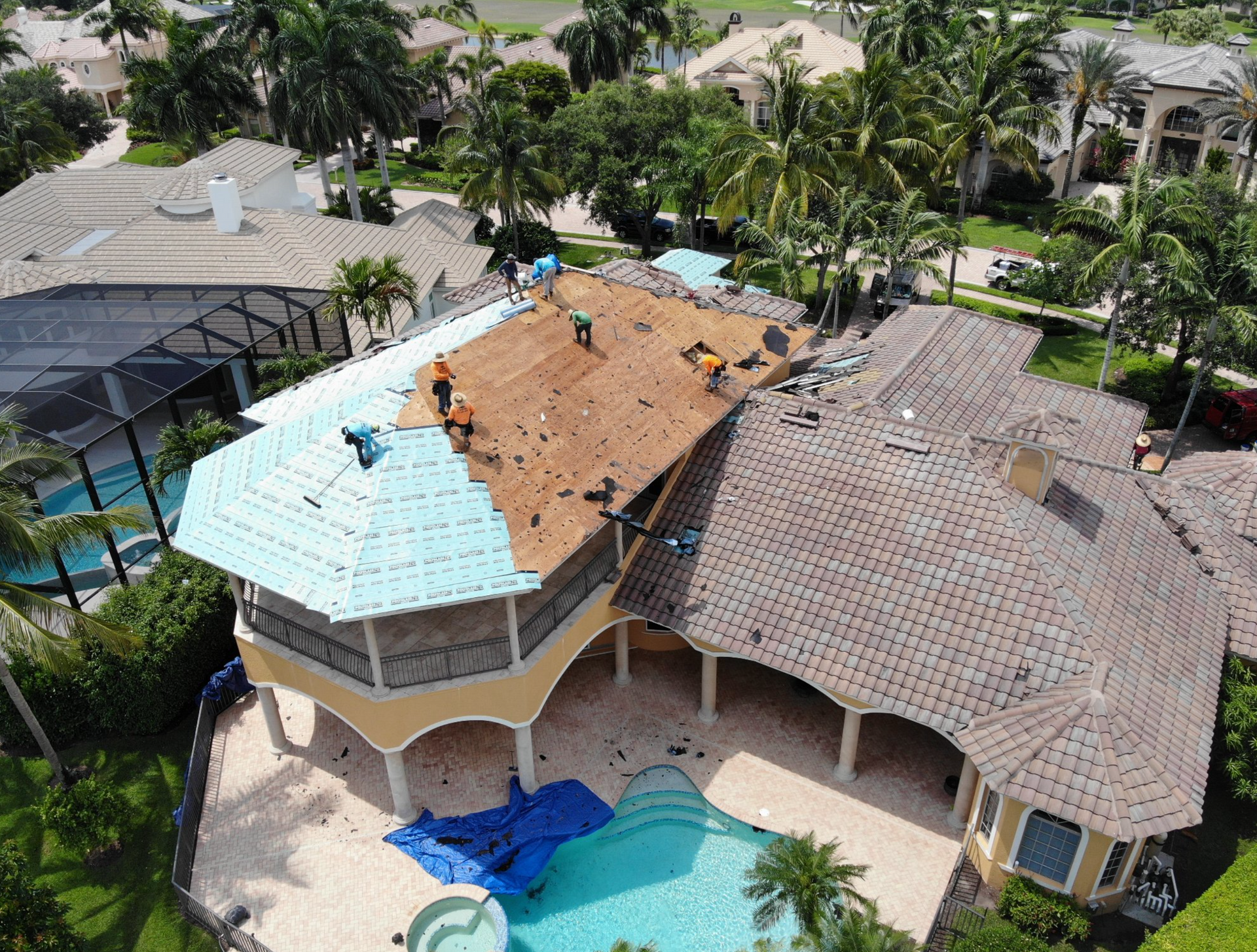 An aerial view of a large house with a pool being remodeled.