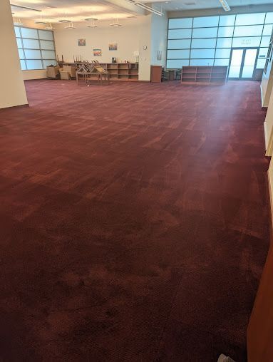 A large room with a red carpet and a lot of windows.