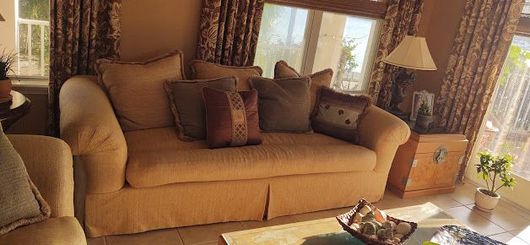 A living room with a couch , chairs , and a coffee table.