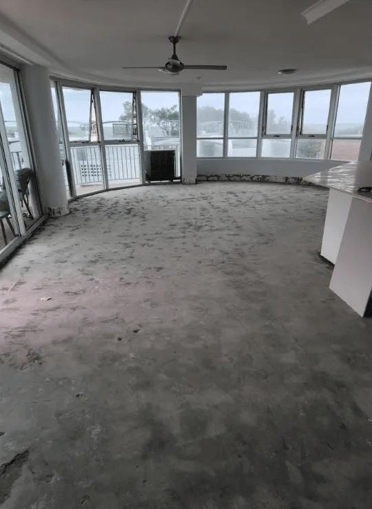 An Empty Room with A Lot of Windows and A Ceiling Fan — TNT Floor Removal & Demolition in Tewantin, QLD