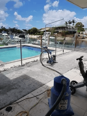 A Grinder Is Sitting Next to A Swimming Pool — TNT Floor Removal & Demolition in Tewantin, QLD