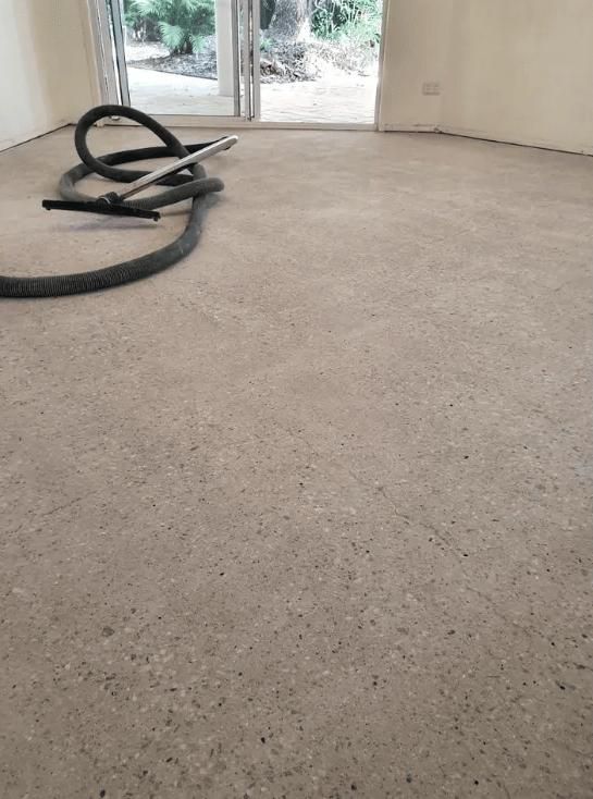 A Cleaner Is Sitting on A Concrete Floor in A Room — TNT Floor Removal & Demolition in Tewantin, QLD