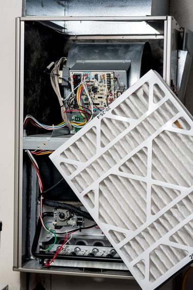 Open electrical cabinet with wires and components exposed, filter panel hanging loose in front.