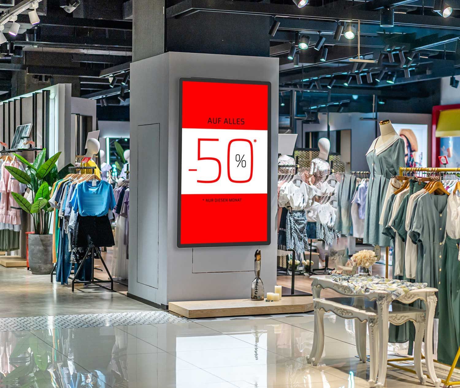 Ein Geschäft mit einem digitalem Monitor mit der Aufschrift „-50 %“.
