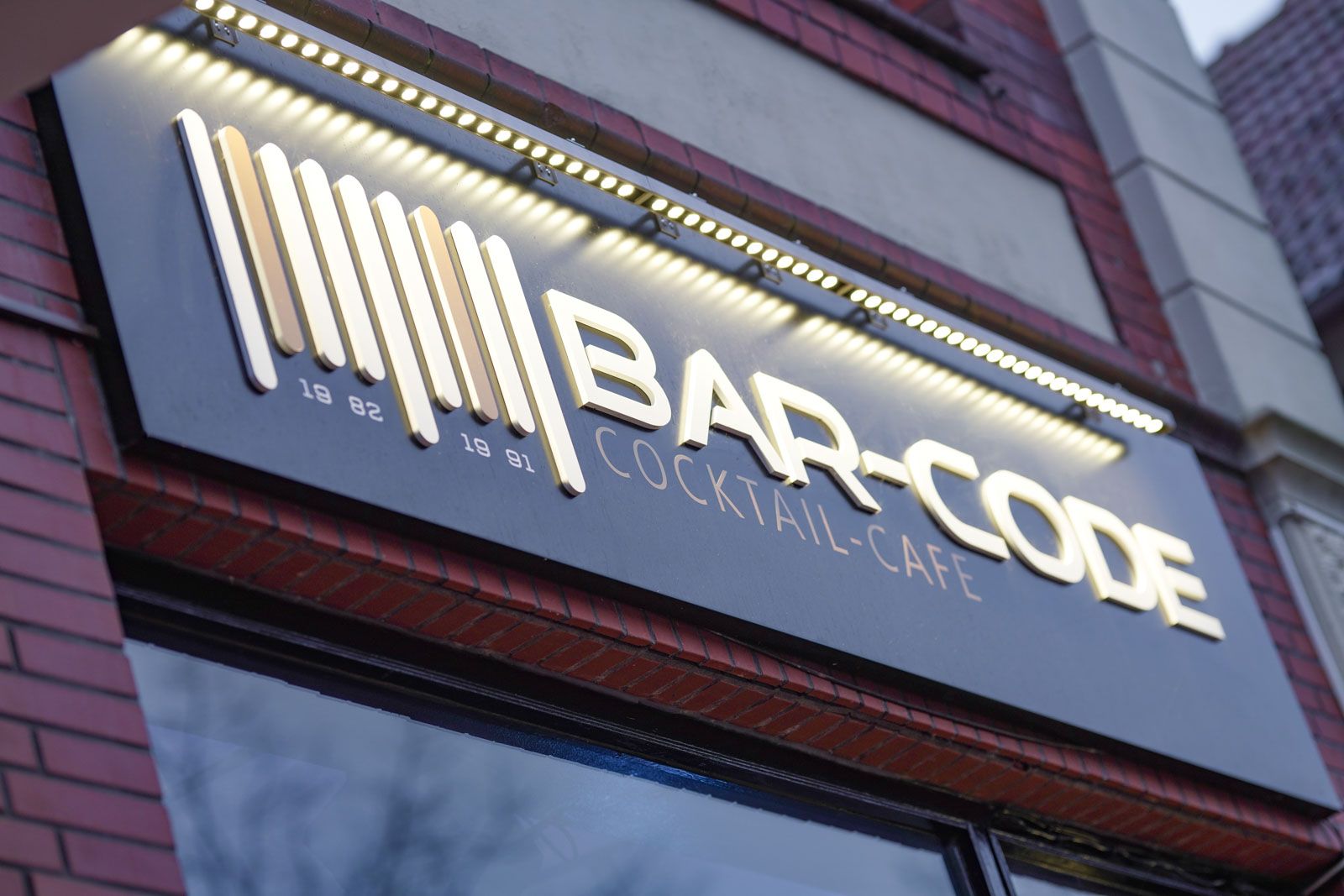Ein Backsteingebäude mit einem Schild mit der Aufschrift „Barcode Cocktail Cafe“
