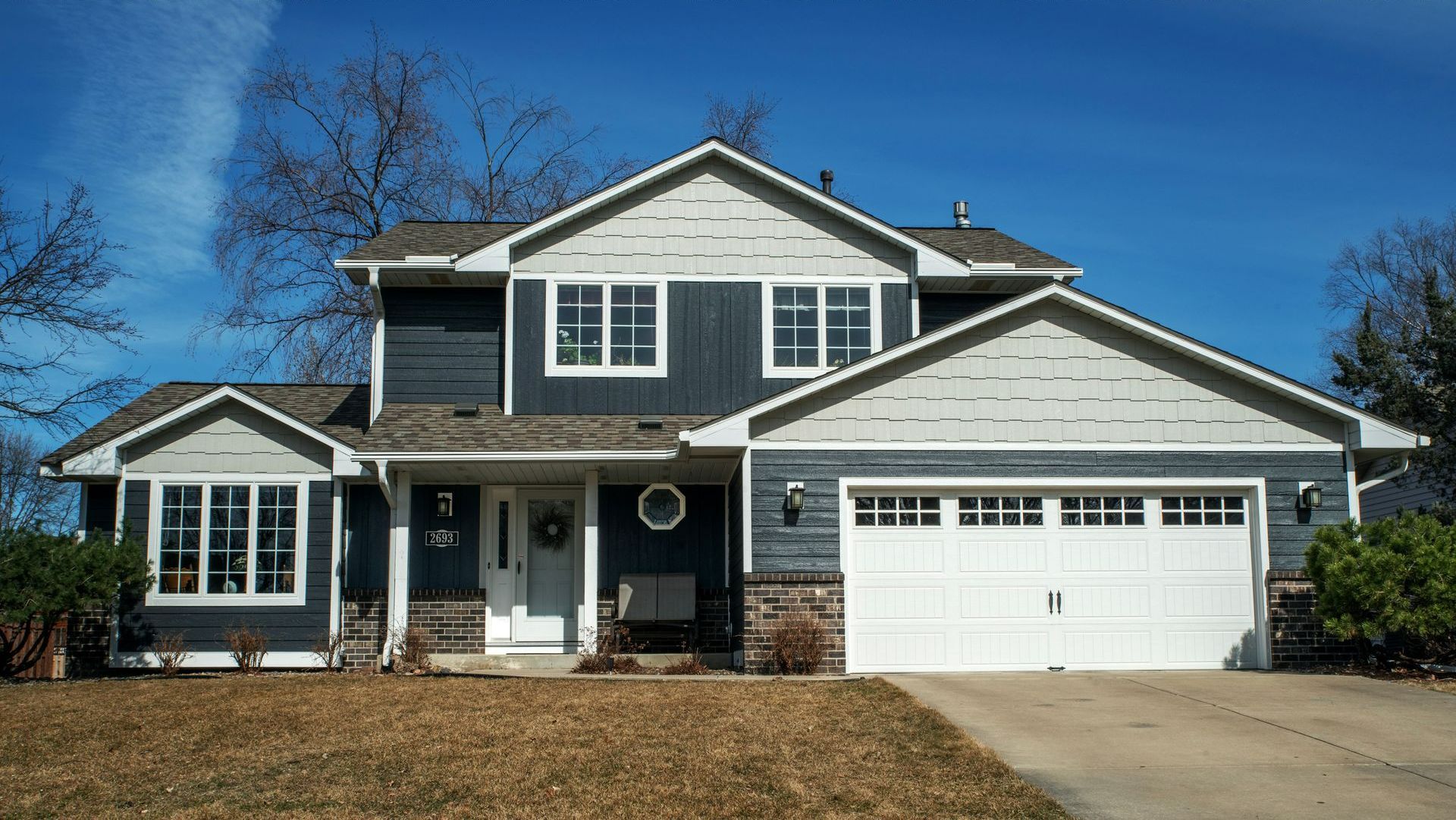 A large house with a blue siding and a white garage door.
