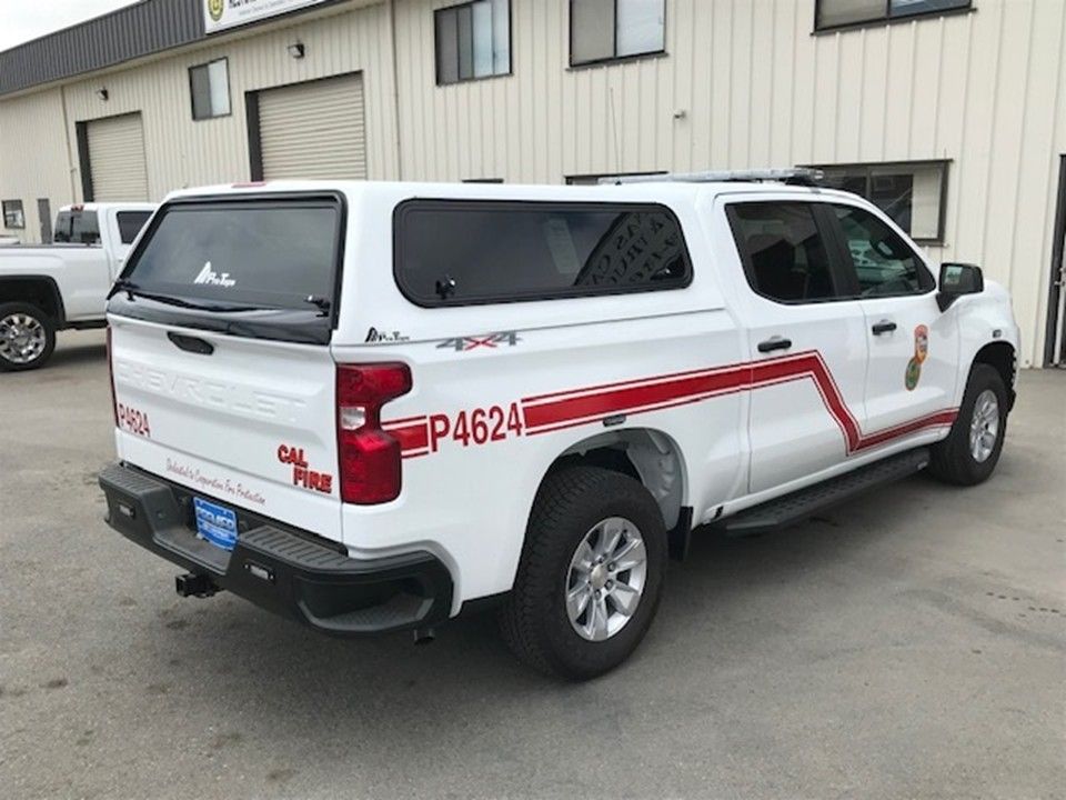 White CAL FIRE pickup truck with a camper shell, marked P4624, parked in an industrial lot.