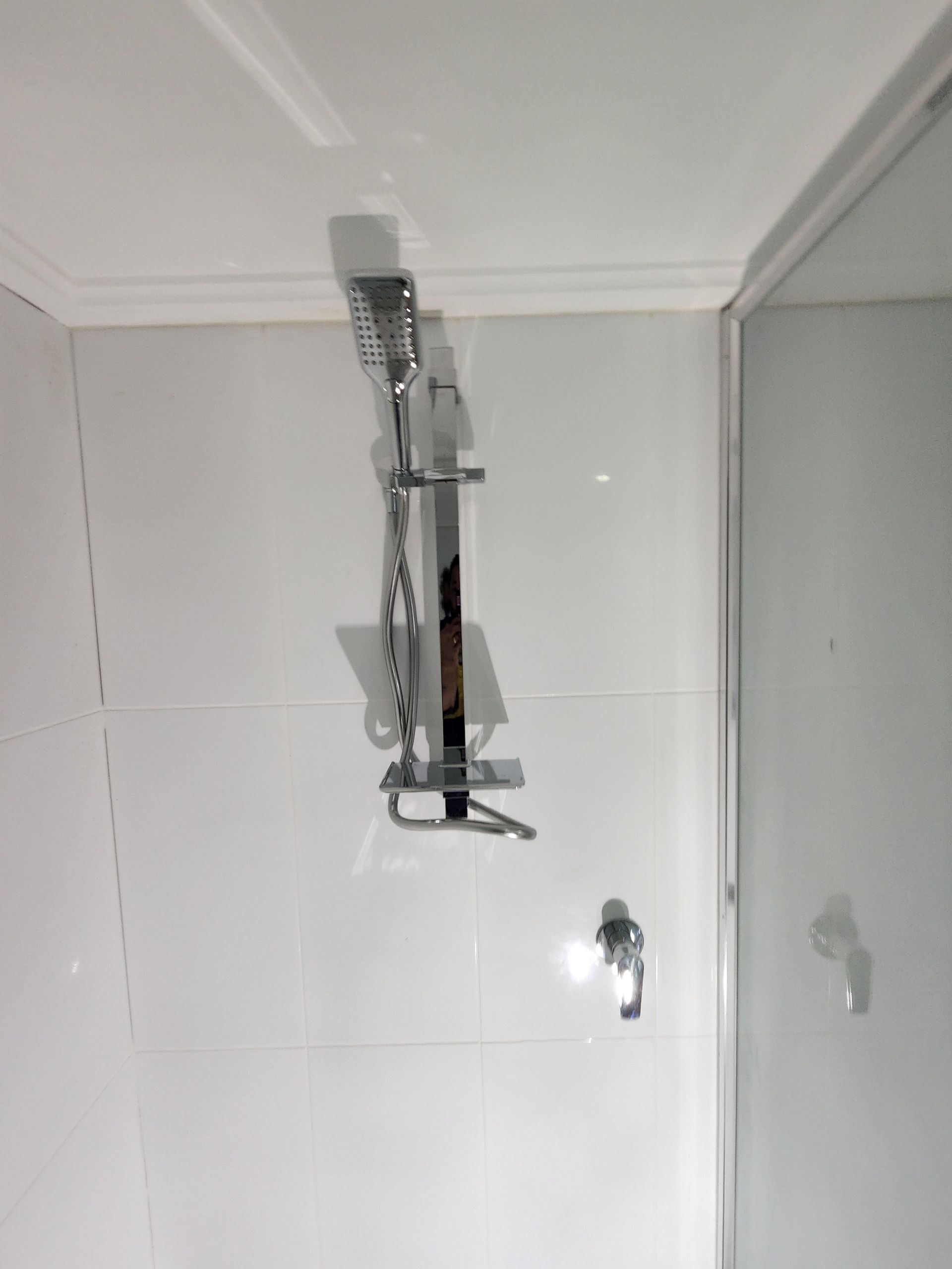 A Chrome Handheld Shower Head Mounted on a Vertical Slide Bar — Kingdom Plumbing Services in Gordonvale, QLD