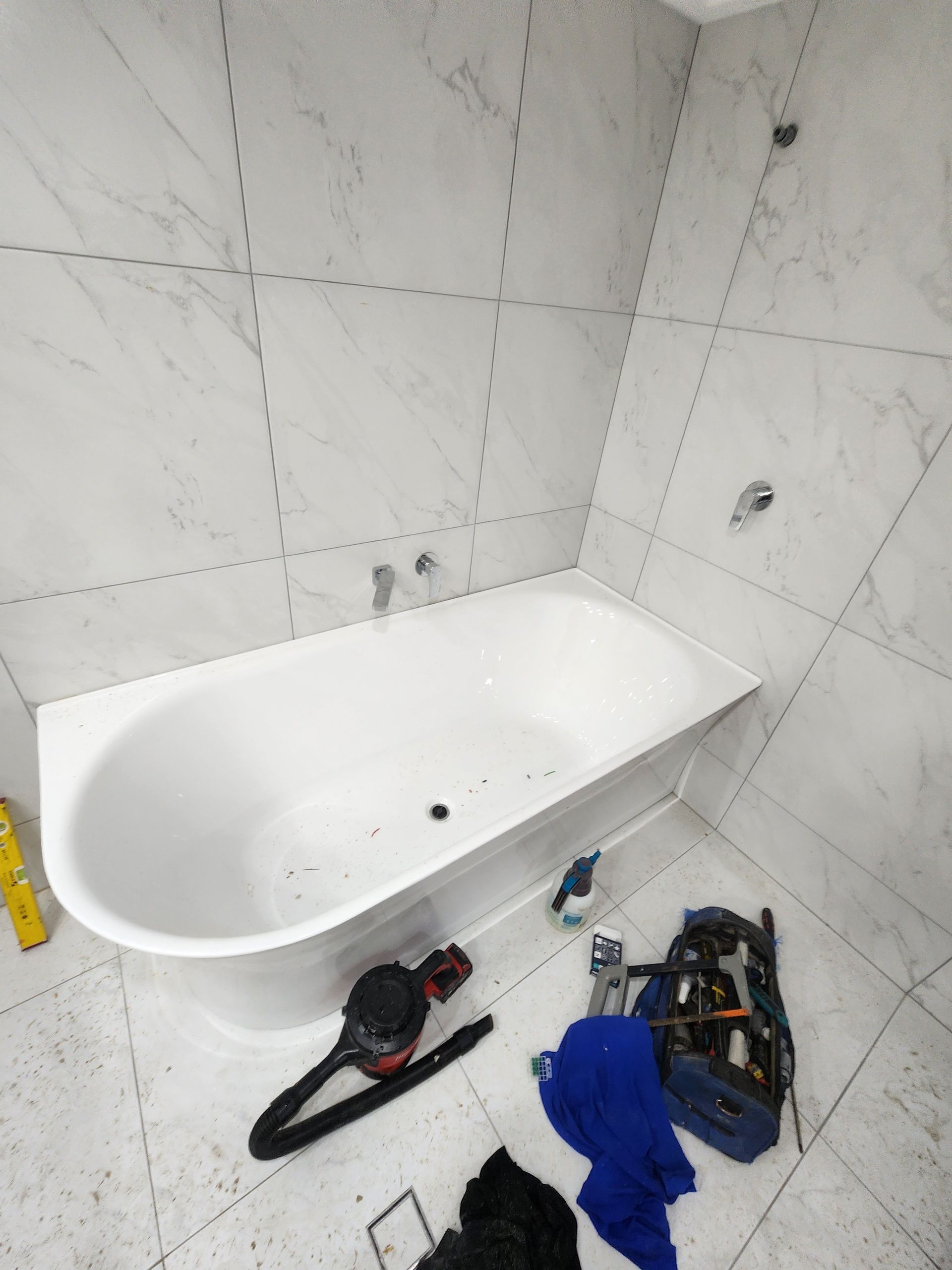 A Hand Holds Two Removed, Worn Metal Faucet Valve Stems — Kingdom Plumbing Services in Gordonvale, QLD