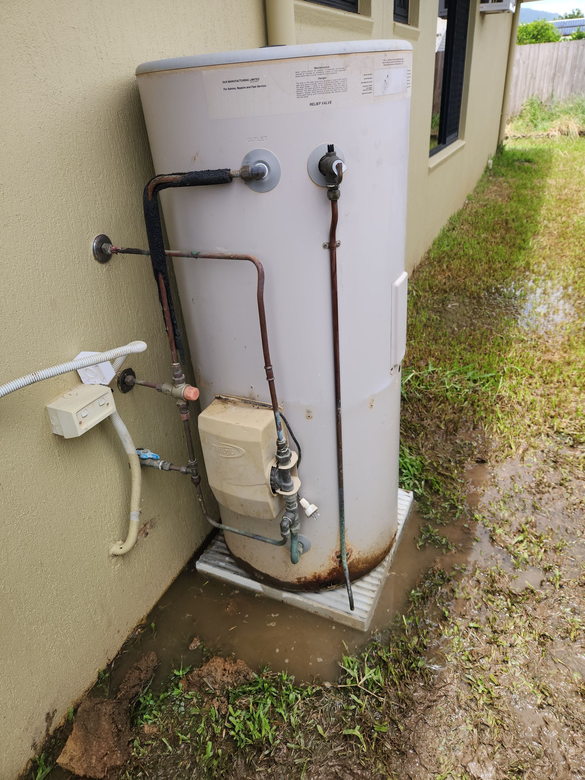 A Water Heater Cylinder Standing on a Concrete Patio — Kingdom Plumbing Services in Gordonvale, QLD