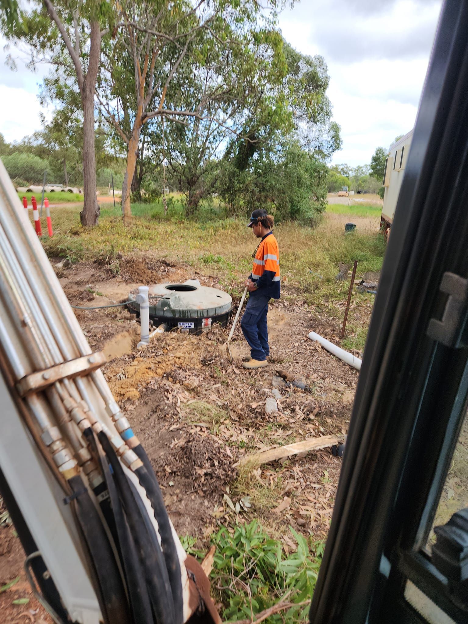 A Construction Worker in a High-visibility Orange Shirt — Kingdom Plumbing Services in Gordonvale, QLD