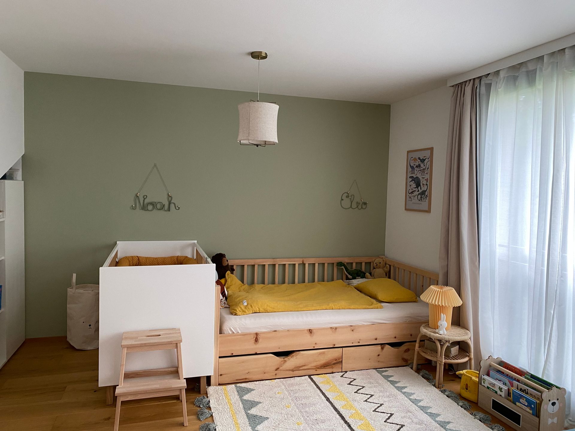 Individuell gefertigtes Kinderbett aus Zirbenholz mit seitlichen Holzstäben und Schubladen unter der Liegefläche