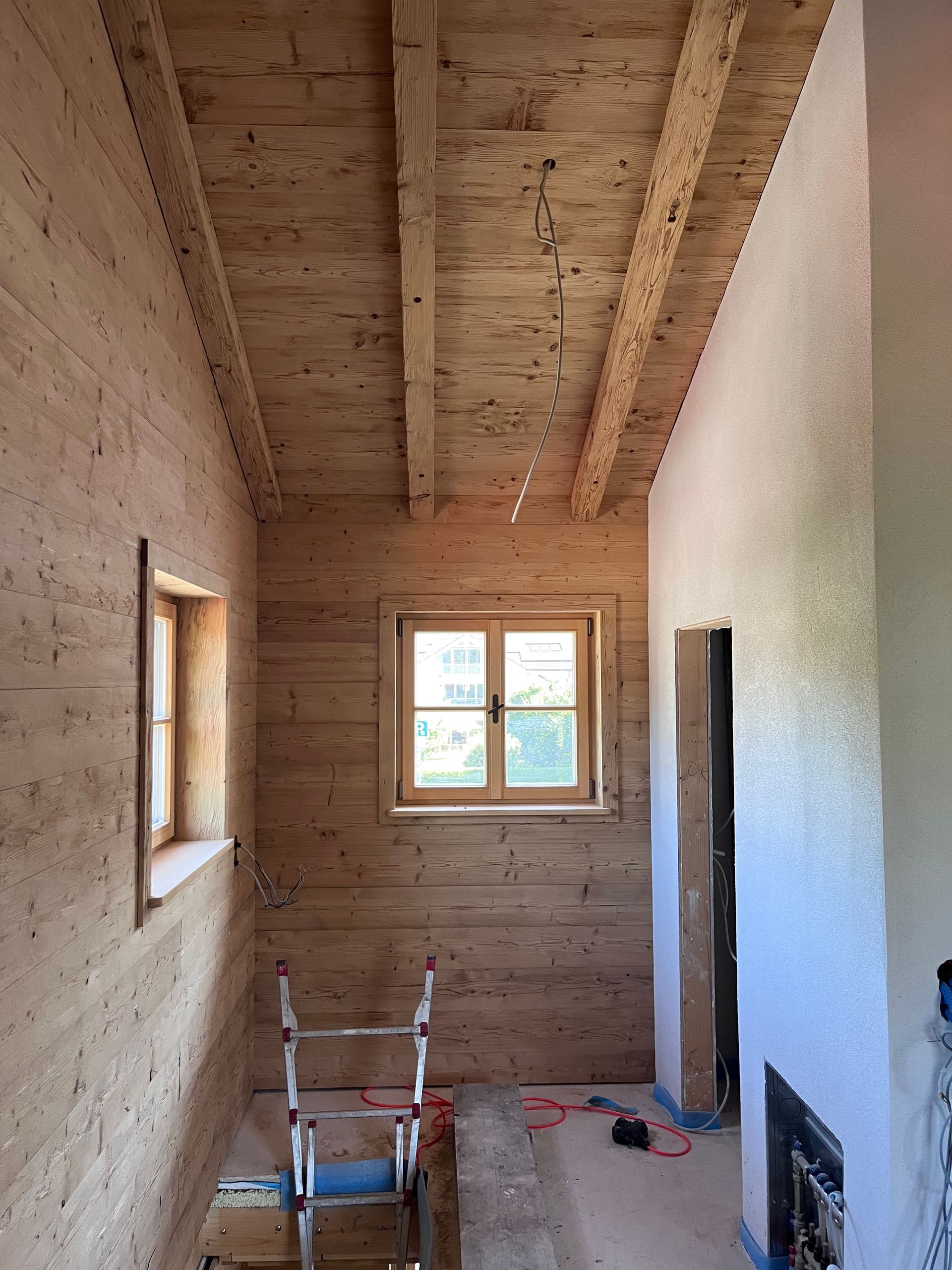Innenausbau mit Nostalgiefichte an Wand und Dachschräge, sichtbaren Balken und angepassten Fensterleibungen