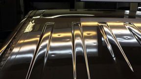 A close up of a row of stainless steel knives on a table.