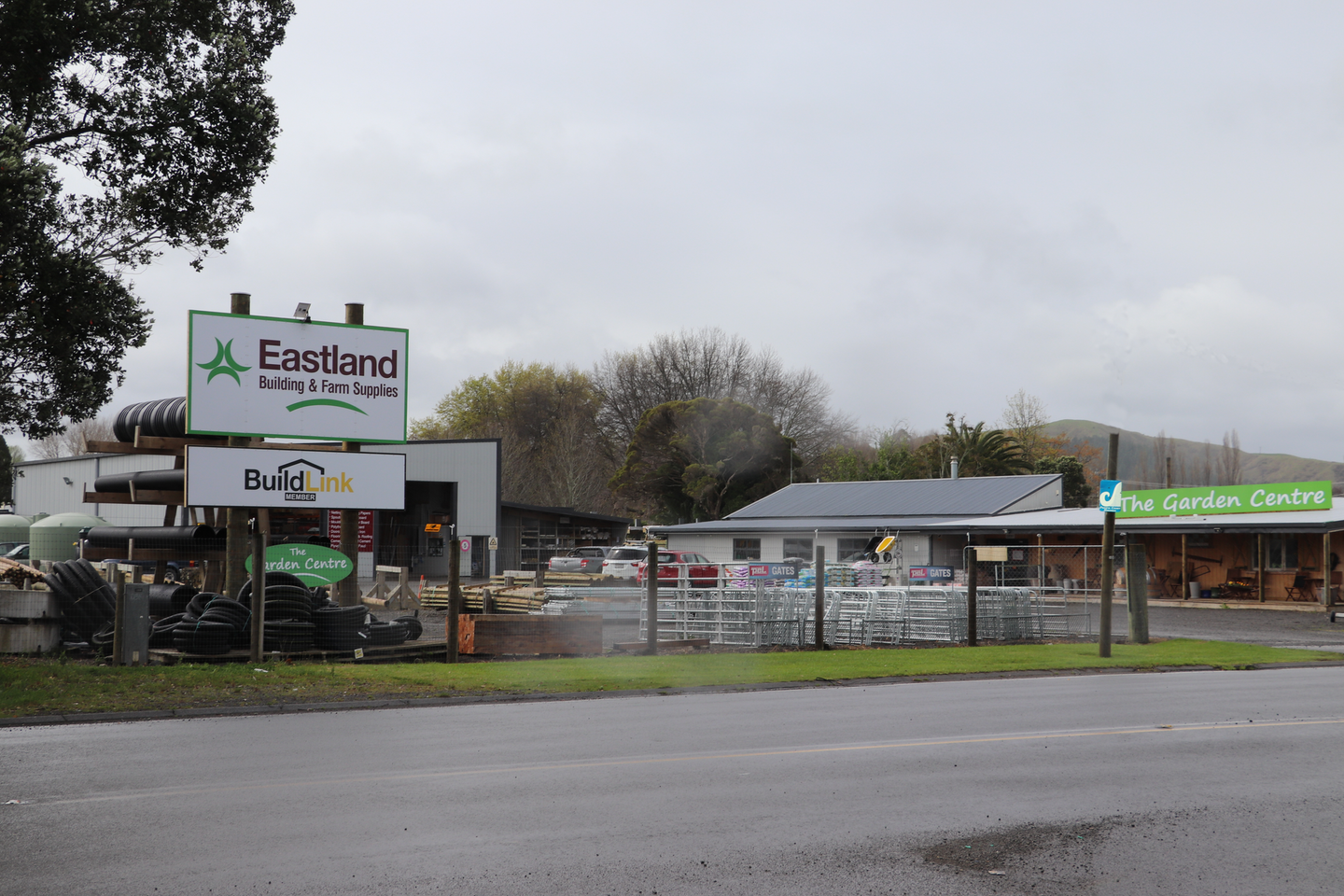 An Eastland Farm Supplies store featuring a BuildLink sign, an outdoor yard, and a garden centre under a cloudy sky.