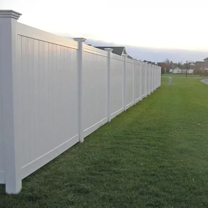 White vinyl privacy fence in a grassy yard.