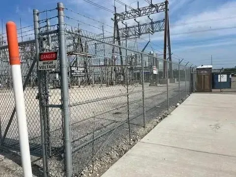 Power substation behind chain link fence with