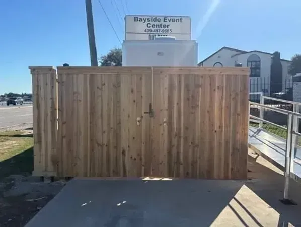 Wooden fence with a gate, a Bayside Event Center sign, and a ramp.