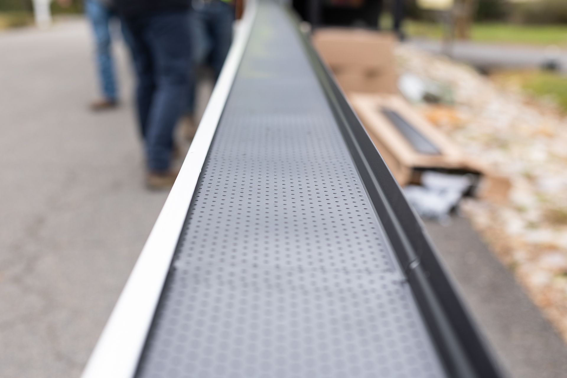 Image of a RETEX crew member installing gutter guards on a Plygem gutter system for a North Chesterfield VA home.