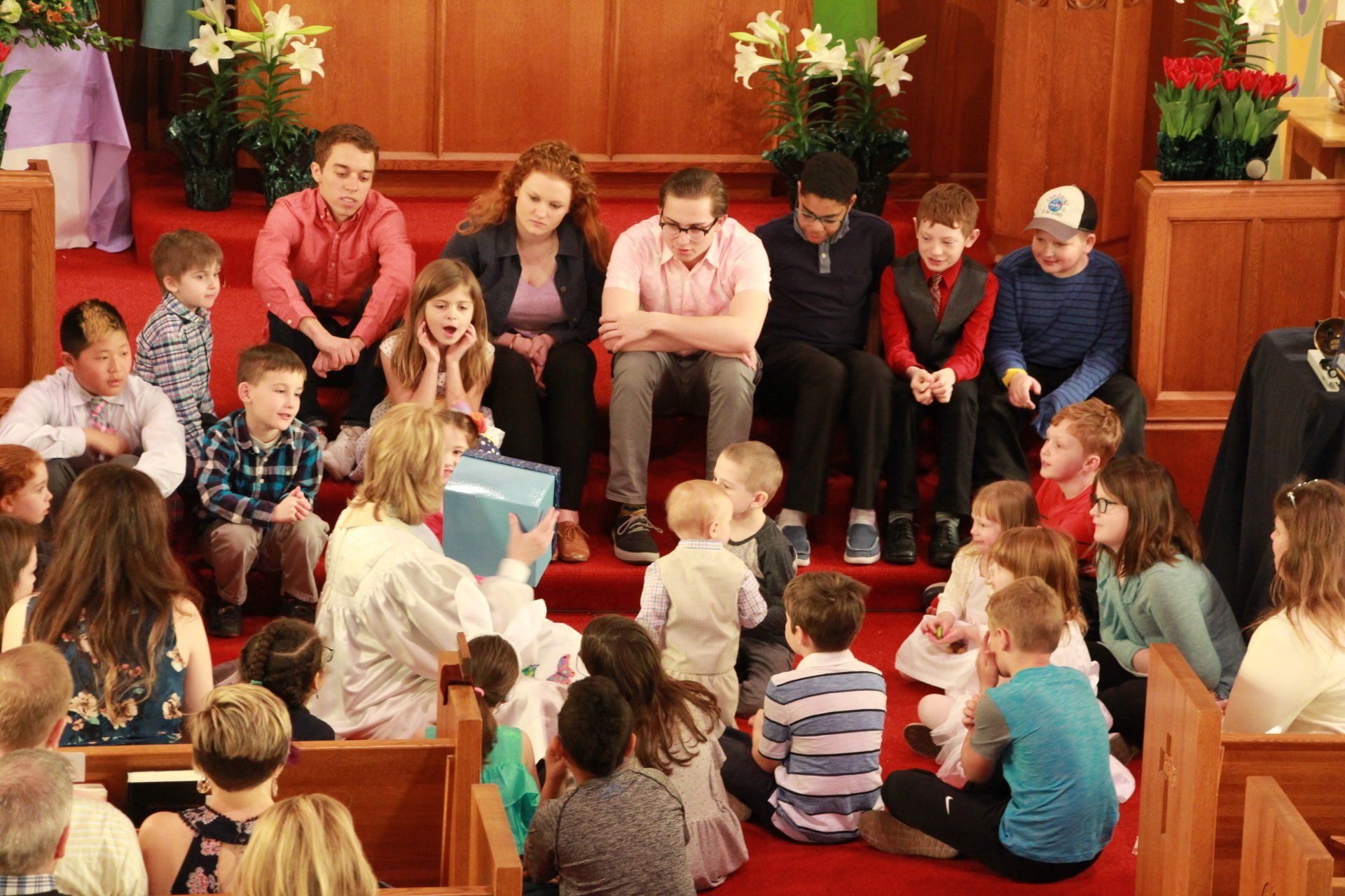 A group of people are sitting on the floor in a church.