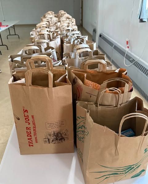 Rows of brown paper grocery bags lined up along a hallway wall