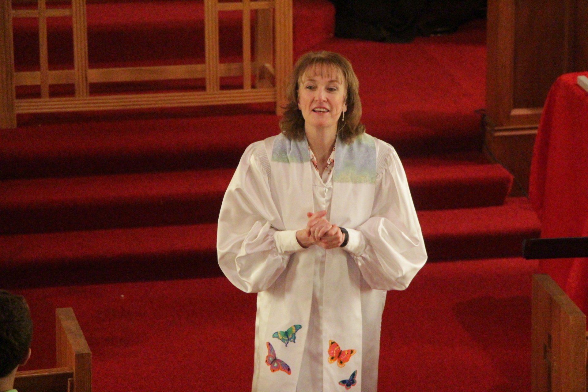 A woman in a white robe with butterflies on it
