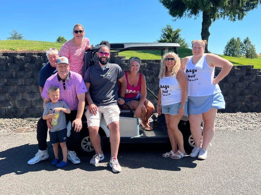 Family and friends gathered around a golf cart at the Rego Golf Classic.